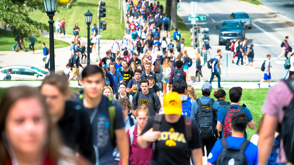 Students walking on the sidewalks of the Pentacrest between classes